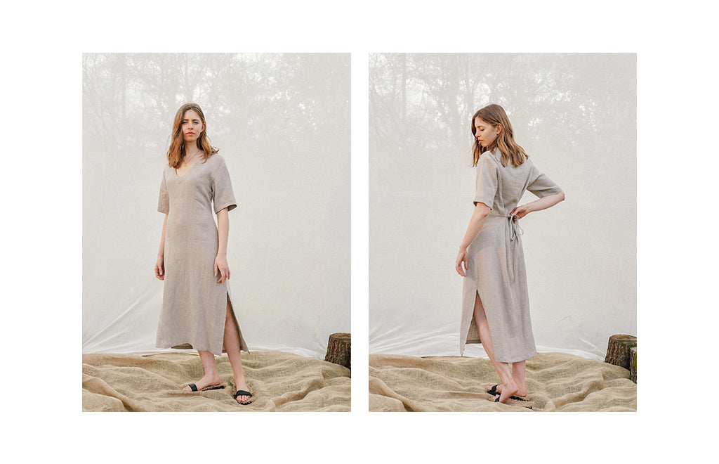 a-brown-haired-model-wears-a-grey-linen-v-cut-short-sleeve-dress-and-sandals